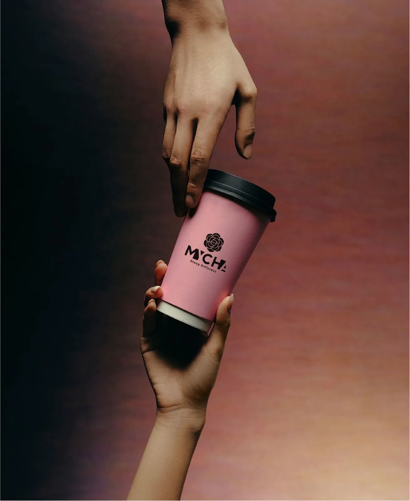 A MYCHA cup held in two hands against a warm pink ground