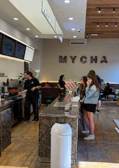 Inside MYCHA Tbilisi: staff behind the stone counter and customers at the bar