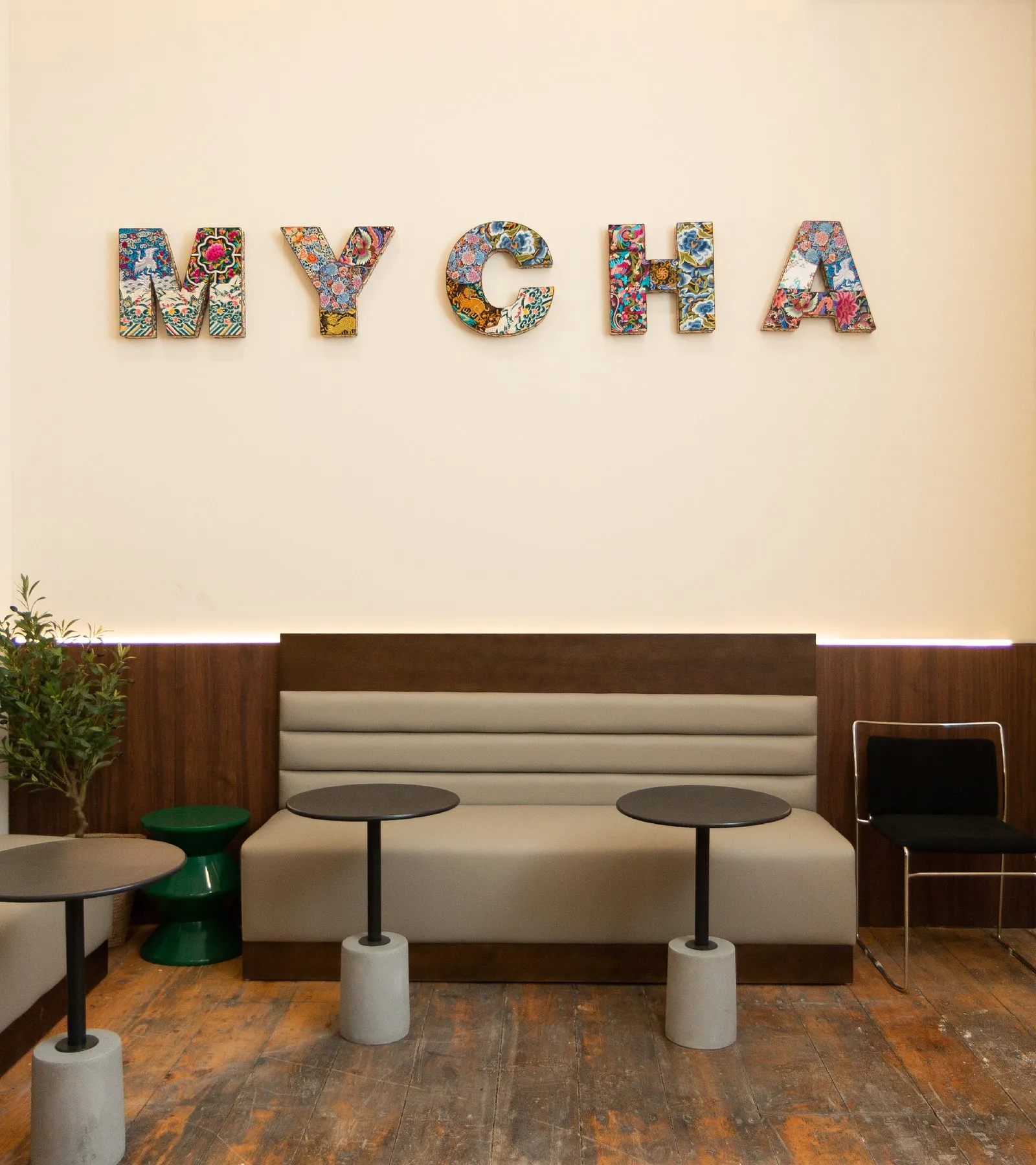Colourful patterned MYCHA letters above a banquette