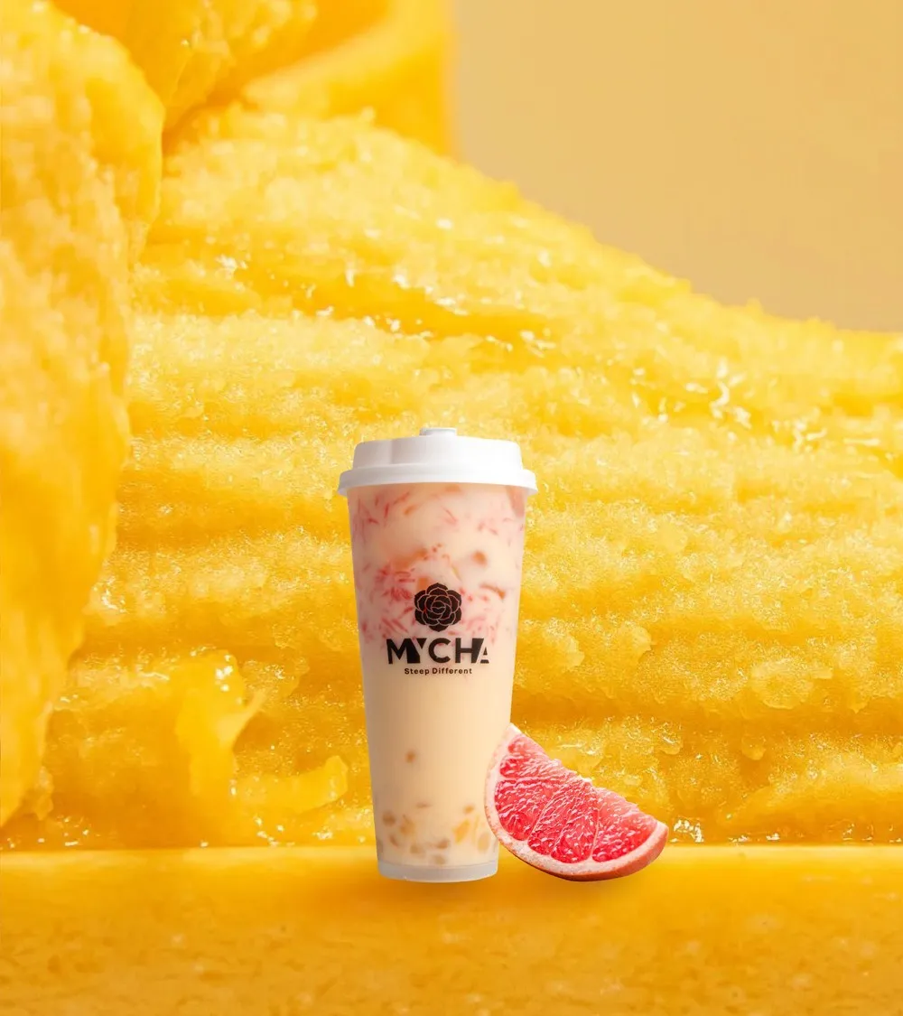 A MYCHA mango pomelo sago with grapefruit and sago against a cut mango ground