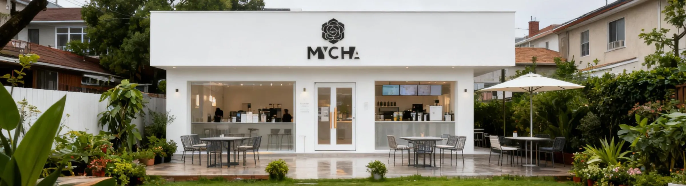 A white MYCHA store in a garden courtyard, with tables and a parasol outside