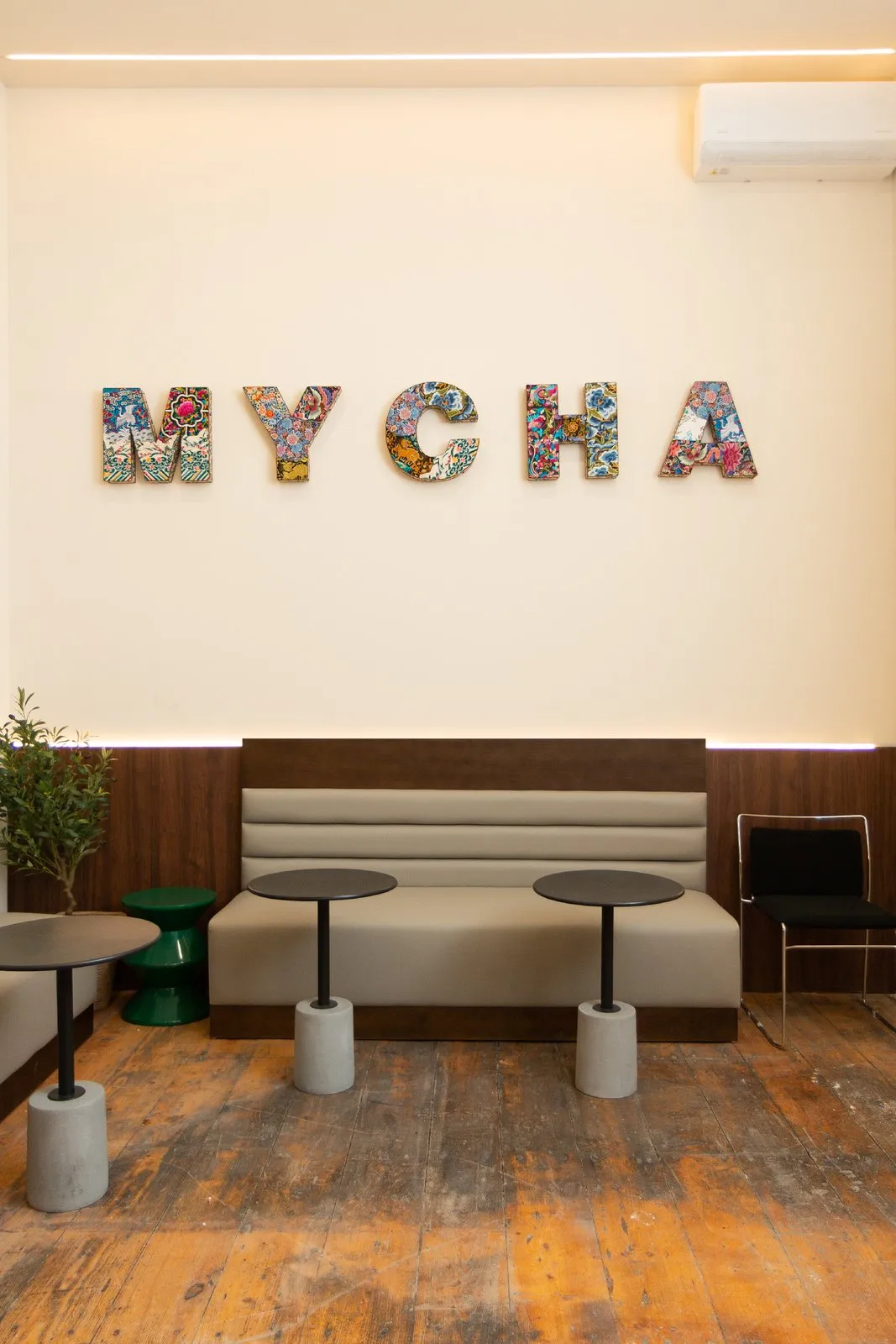 Tessellated MYCHA letters in a local pattern above banquette seating